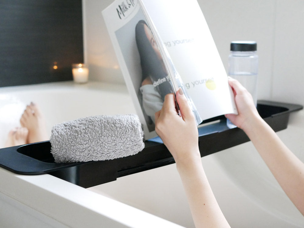 ブランドYamazakiの伸縮可能なABS樹脂製バスタブトレー。幅57.5~75cmに調整でき、浴槽内にフィットします。