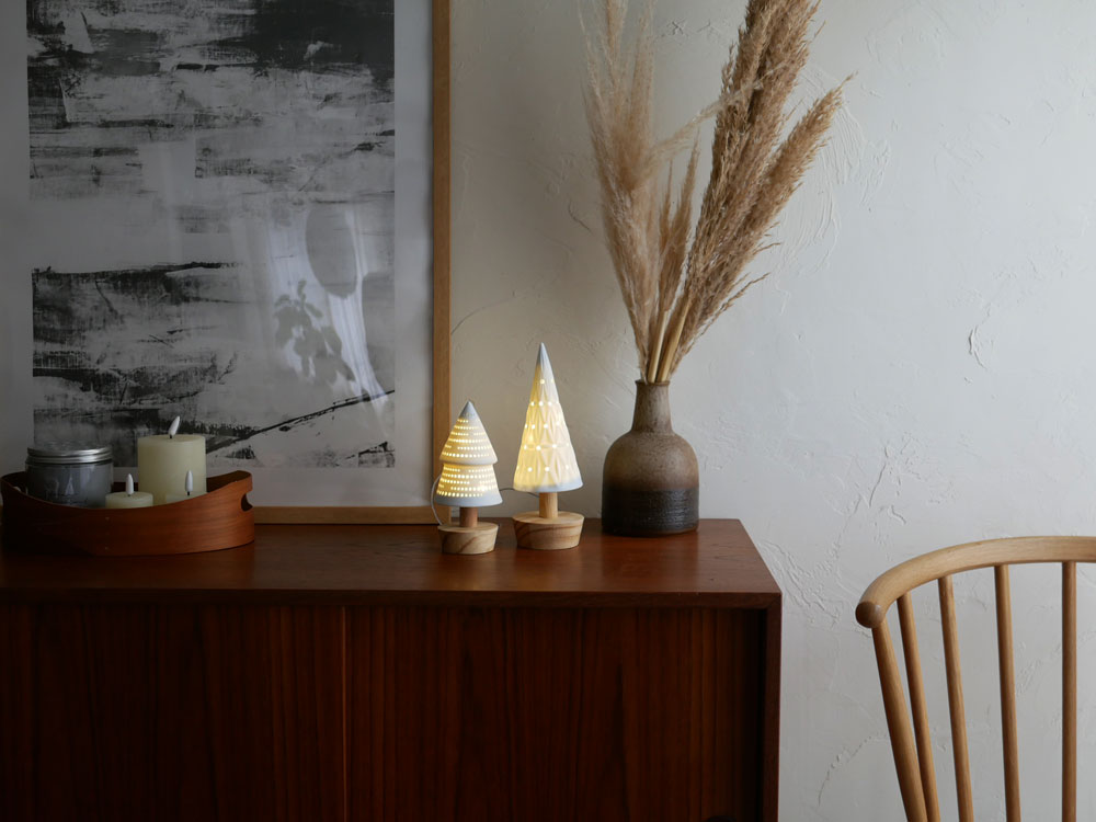 Horn Pleaseの木製LEDライトPOTTERYツリー。パインウッドを使用し、自然なデザインに点灯するLEDライトが飾られた装飾用ツリー