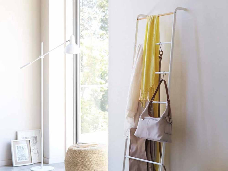 Yamazakiタワー製の木製ラダーハンガーが室内インテリアとして椅子やランプと共に配置されている様子