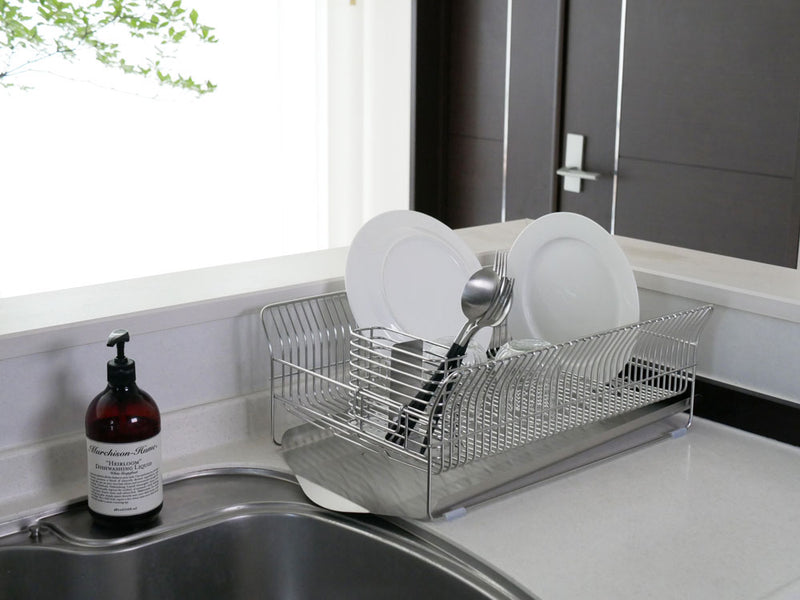 ハナウタ製ローズゴールドメッキのステンレス横置き水切りラックがキッチンカウンター上で食器やカトラリーを整理している様子