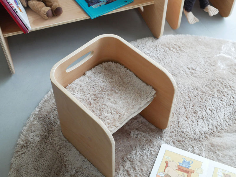 ホップルのコロコロチェア専用チェアパッドが木製の床に敷かれ、子供が快適に座っている様子