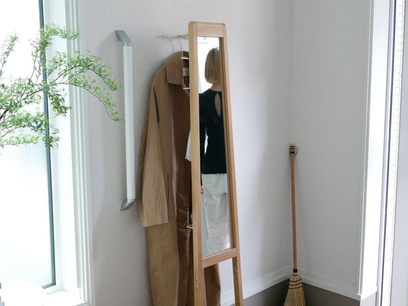 天然木フレームの「リヴ 立て掛けミラー」が木製フローリングの上に清潔感を持って配置されているインテリアの様子