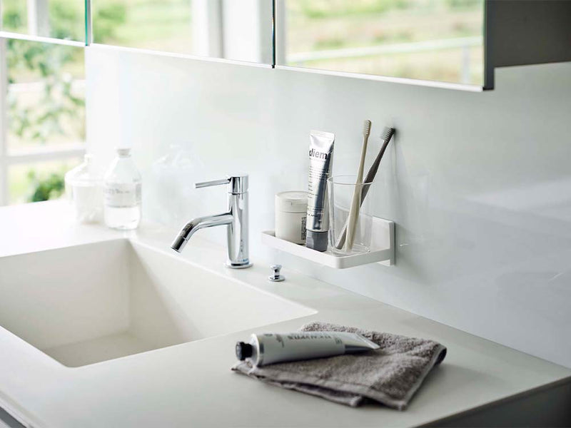 白色フィルムフックトレー「PLATE」を設置したバスルームの洗面台。シンク、蛇口、バスキャビネットが整然と配置されたインテリア