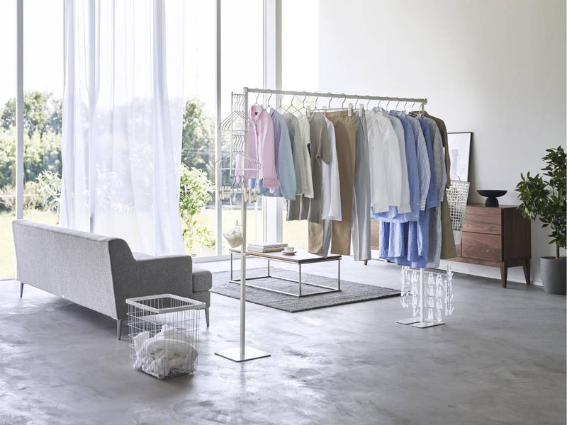 リビングルームの床に設置された灰色と銀色のスチール製タワー折り畳み室内物干しラック