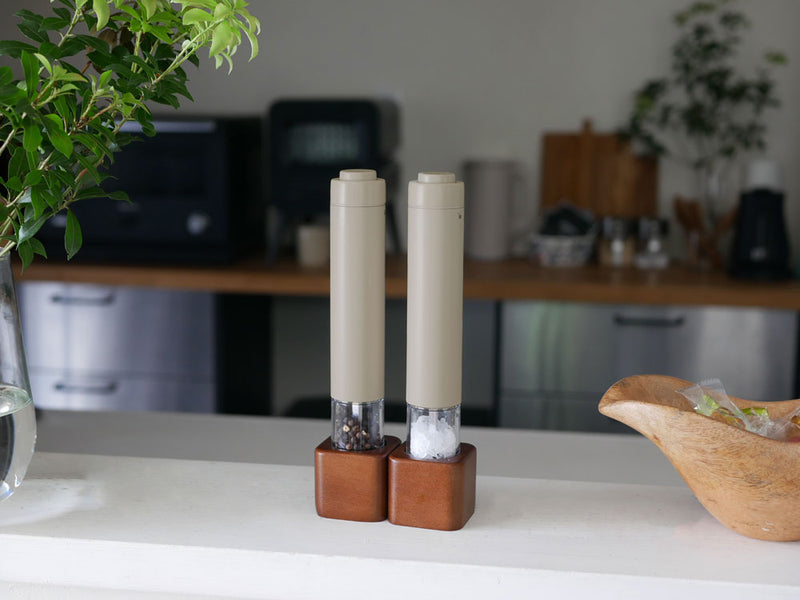 アカシアスタンドに置かれたレコルトの電動ソルト&ペッパーミルと花瓶、キャンドルホルダーが並ぶ静物写真