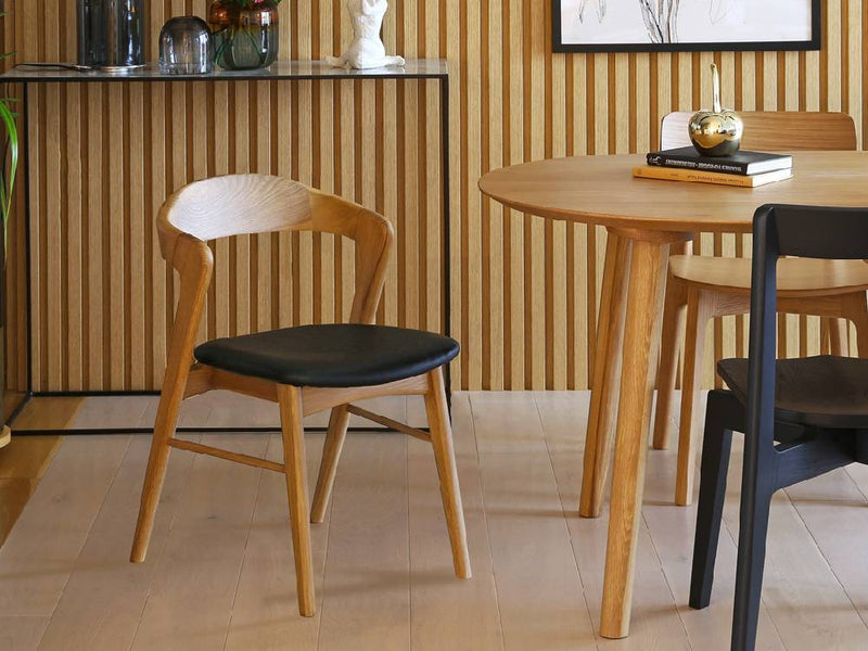 高野木工のSWELLダイニングチェアが木製ダイニングテーブルと共に木の床に配置されたダイニングルーム