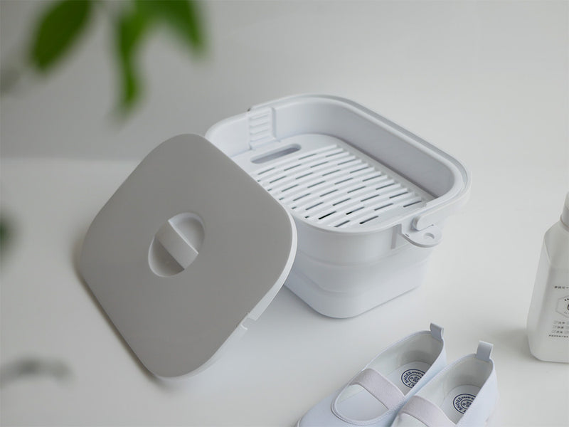 プラスチック製の折りたためるつけ置き洗いバケツ。ふたと洗濯板がセットされた家庭用キッチン用品。