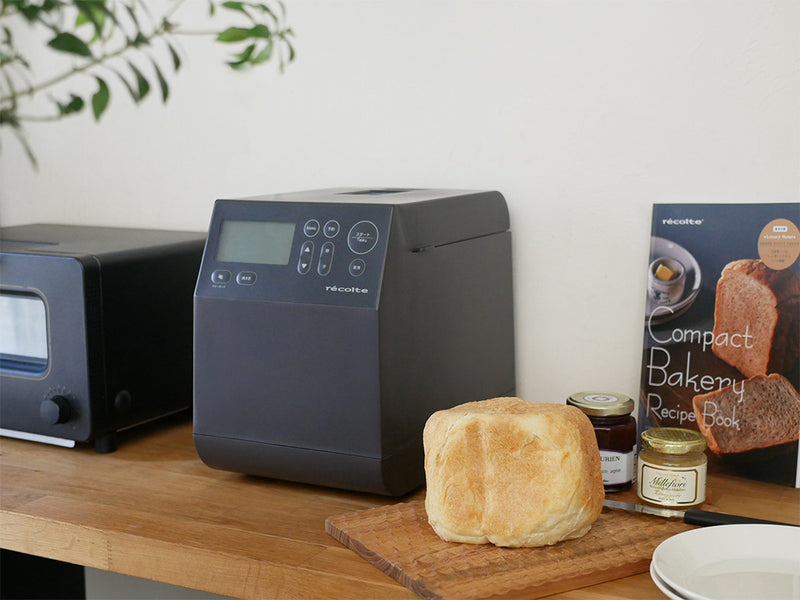 レコルトのコンパクトベーカリー本体と付属品が並んだキッチン家電の写真