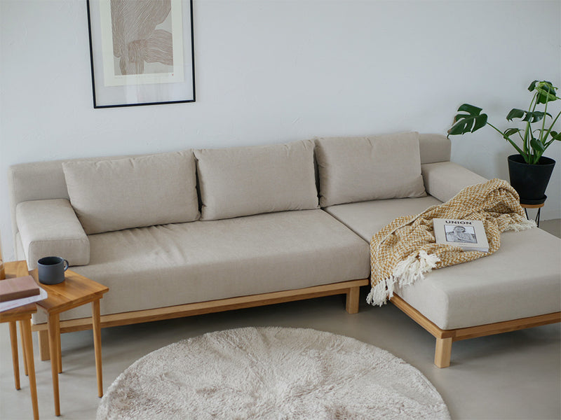 木製フロアに配置された【SIEVE/シーブ】ゆったり座れるレクトユニットソファーとクッションがあるリビングルームのインテリア