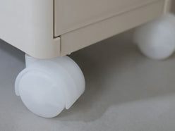 クリアまたはブラックのプラスチック製キャスターが取り付けられた引き出し付きナイトスタンド