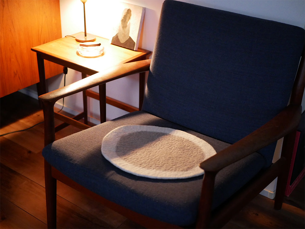 木製の床の上に置かれたHinata Lifeのウールフェルトチェアシート