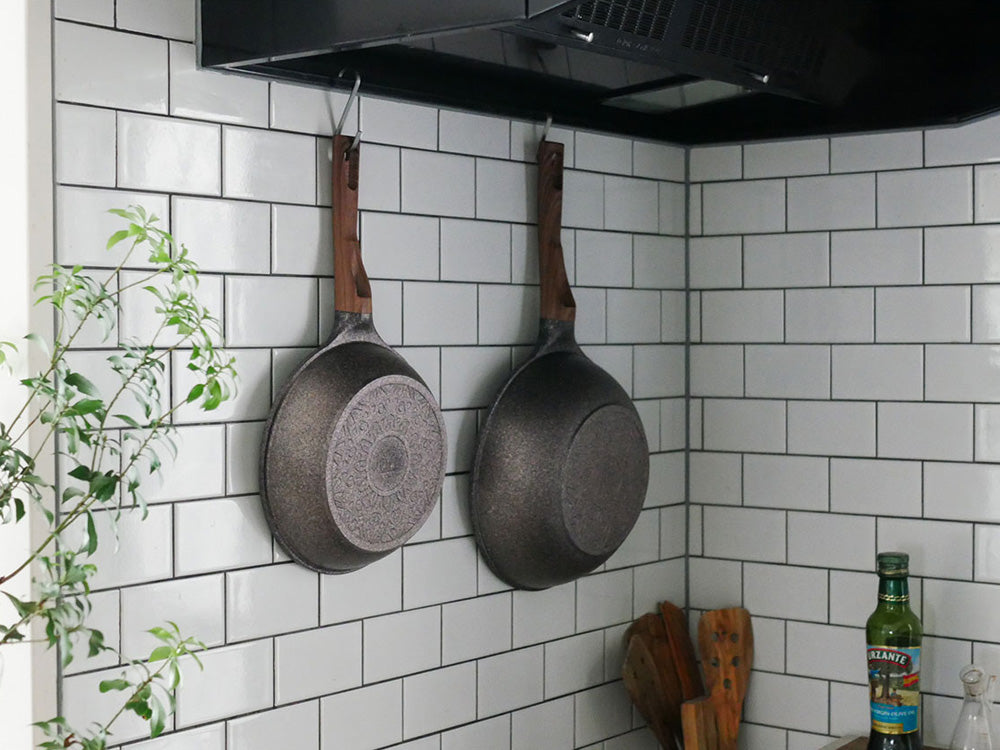 キッチンの鍋棚に協和工業のムテキバリアフライパンセットが整然と吊るされている様子