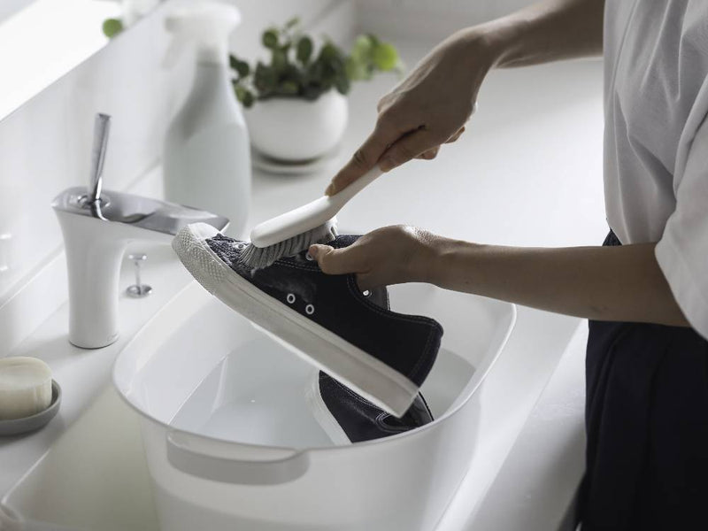 浴室のシンク横にシルバーの蛇口とともに置かれた【marna/マーナ】きれいに洗えるシューズブラシ。清潔感のあるバスルームの雰囲気を演出しています。