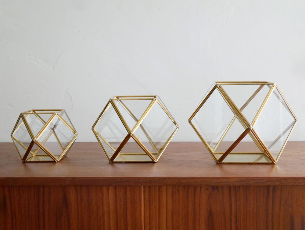 Horn Please MADEの金色真鍮フレームを持つ三角形ガラスケース内のフィギュア