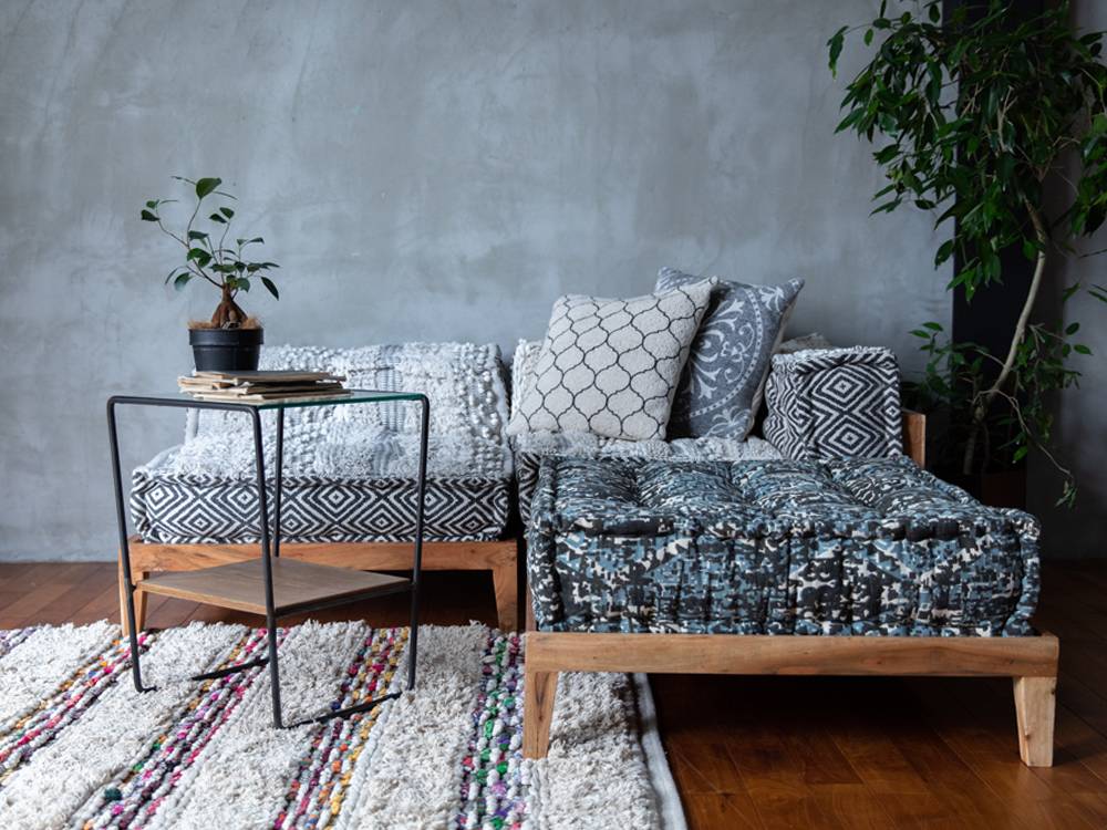 グレーと銀色のモチーフクッションが並ぶソファ