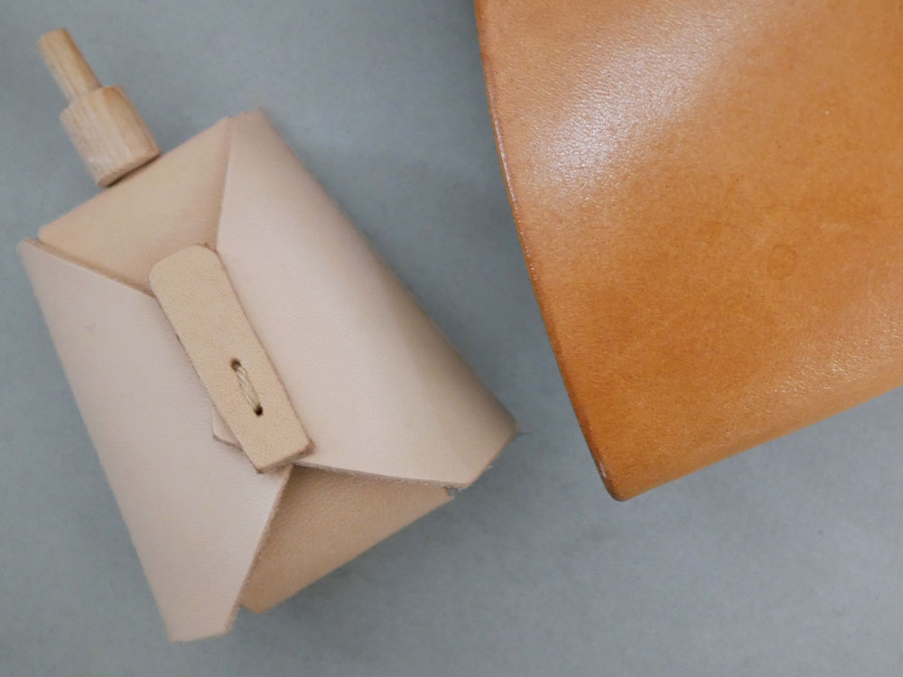 Comore Sunのヌメ革とヒノキで作られた伝統的なお雛様セット、木製台座に配置された人形