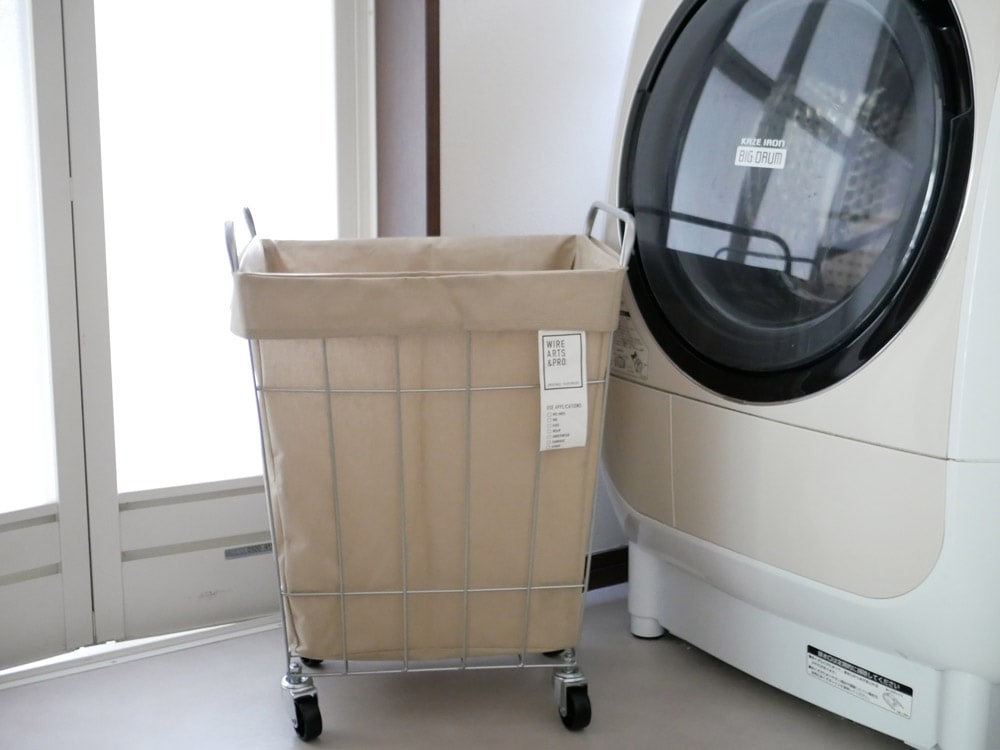 洗濯機と衣類乾燥機の横に配置されたBRIDブランドのキャスター付き45リットルランドリーストレージボックス