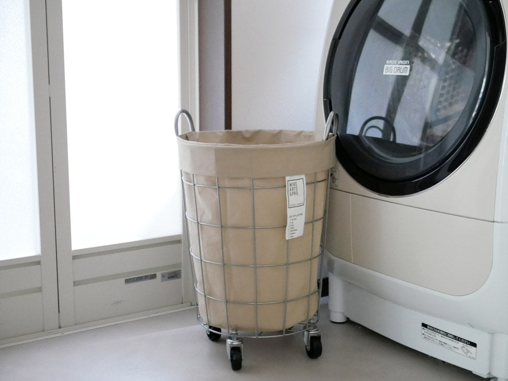 BRIDのランドリーストレージ ラウンド33Lが配置された洗濯室内に洗濯機と乾燥機が並んでいる様子