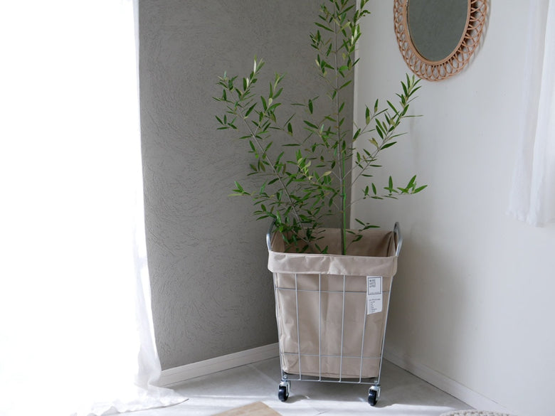 BRIDのランドリーストレージ スクエア45L、キャスター付きスチール製収納ボックスと花鉢やハードウッドが調和したインテリアデザイン