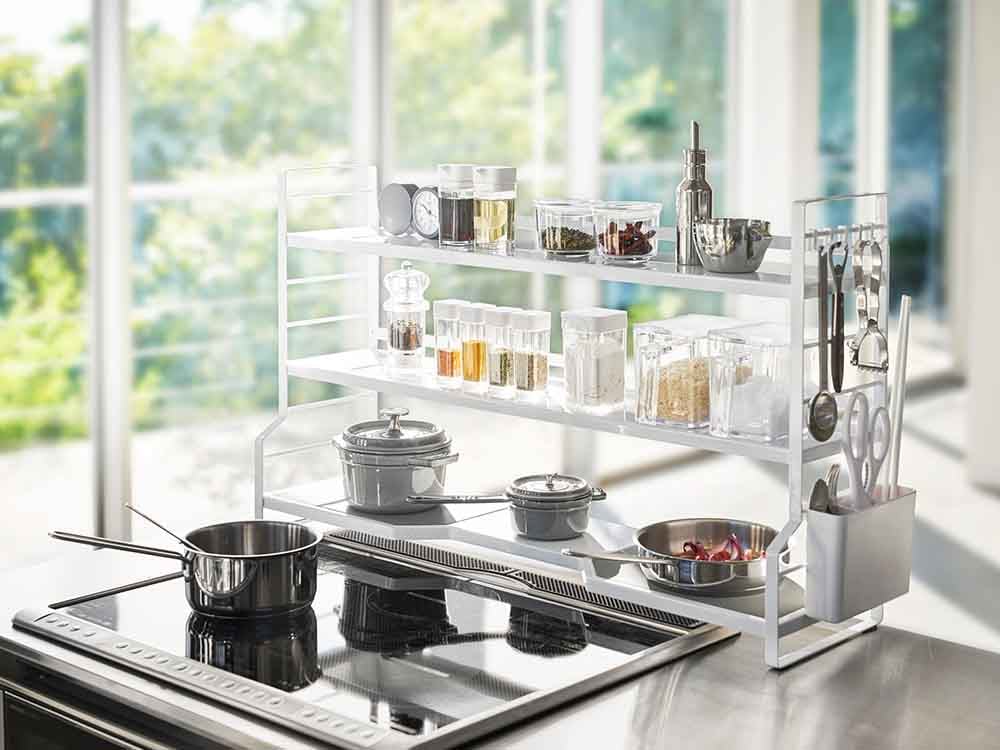 YAMAZAKI/towerのスチール製コンロ奥ラックがキッチンカウンター上に設置され、複数の棚とカトラリーポケットが見える収納具
