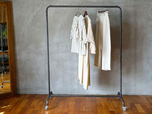 クローゼット内のアイアンハンギングスタンドと衣類