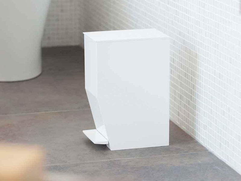 バスルームに設置されたYAMAZAKI/towerのペダル式トイレポット。周囲にはプラスチック製の花鉢やデザインタイルが配置され、モダンな雰囲気を演出しています。