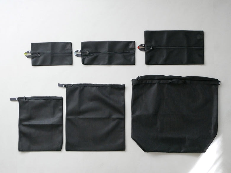 サラサデザインの黒色ランドリーネットバッグ。ポリエステル製でショルダーストラップ付き、複数のポケットを持つ洗濯用収納バッグ。