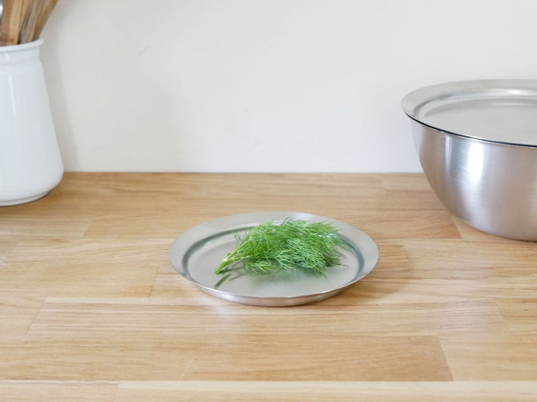 la baseの18-8ステンレス製ボウル、ざる、プレートが木の床に整然と並べられたキッチンウェアセット