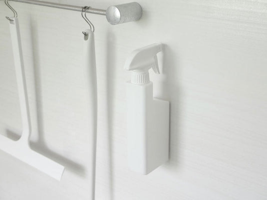 タワーの白いマグネットスプレーボトルが壁に取り付けられている