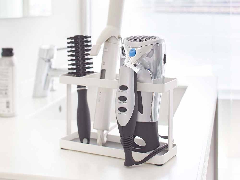 YAMAZAKIタワー製シルバーカラーのドライヤー＆ヘアアイロンスタンド。スチールとプラスチック素材を使用し、扉用フックやコード用フックが付属した小型の個人ケア家電用スタンド