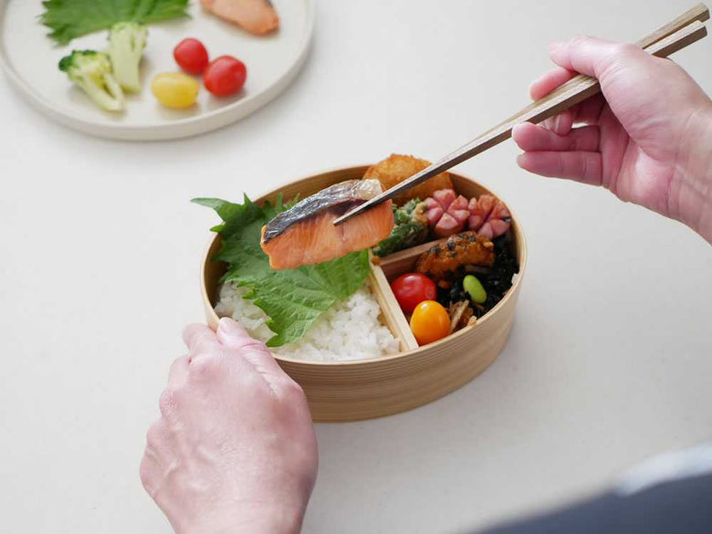木製曲げわっぱに盛られた白米と野菜、箸
