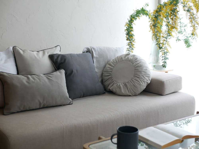 リビングルームのソファに置かれたグレーのキャンバスクッション