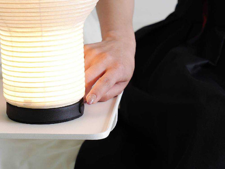 和紙とスチール製のボボリポータブルランプが木床に置かれている