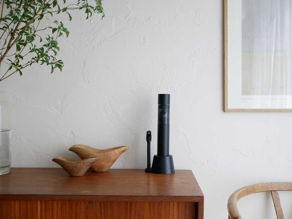 観葉植物が入った花瓶とシリンダーランプが置かれた室内