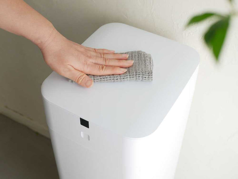 木製フロアと花鉢が配置された自動ゴミ箱