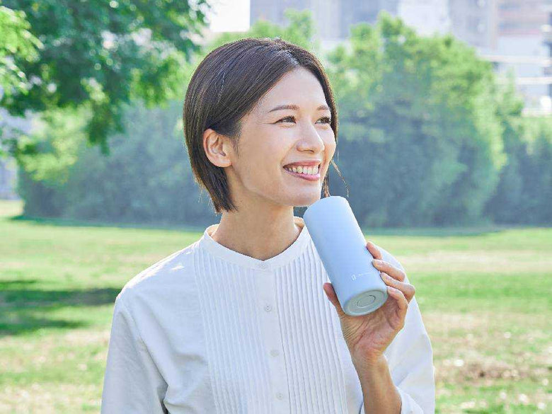 自然の中でヒヤシーナの氷タオルを使用し笑顔を見せる人々