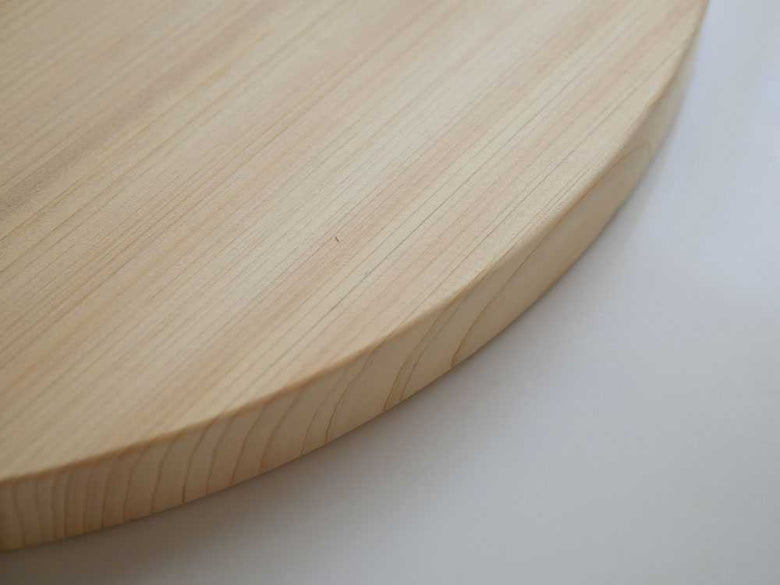 ヒノキの丸いまな板がスタンドに立てられている様子