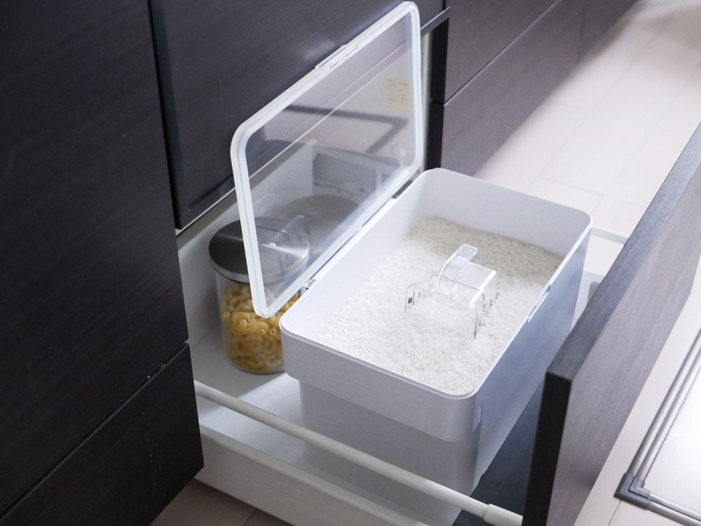 YAMAZAKIのタワー密閉シンク下米びつ。グレーとシルバーのキッチンキャビネット内に配置された引き出しと棚が特徴で、計量カップが付属しています。