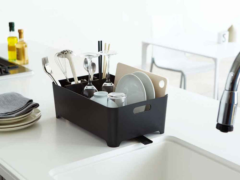 YAMAZAKI/towerのABS樹脂製水切りバスケットがキッチンのカウンター上に置かれ、シンクやキッチン用具と共に整理整頓されている様子