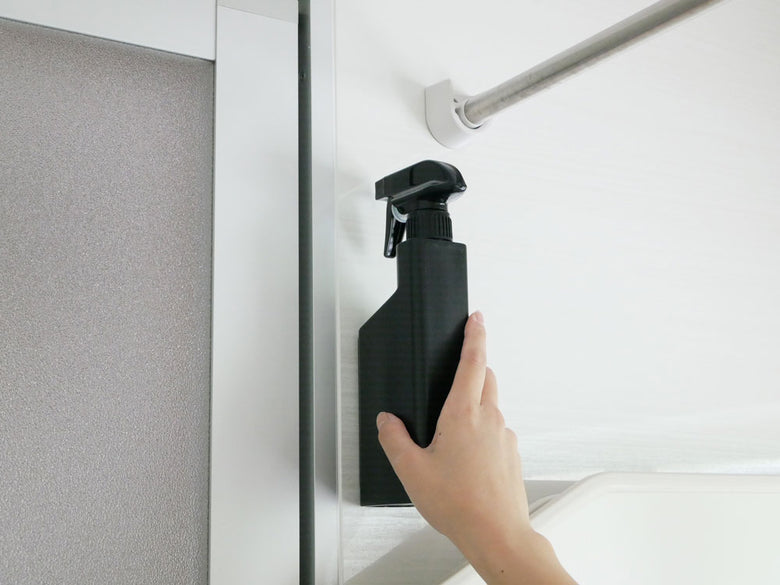 タワーのマグネットスプレーボトルがバスルームの壁に設置されている