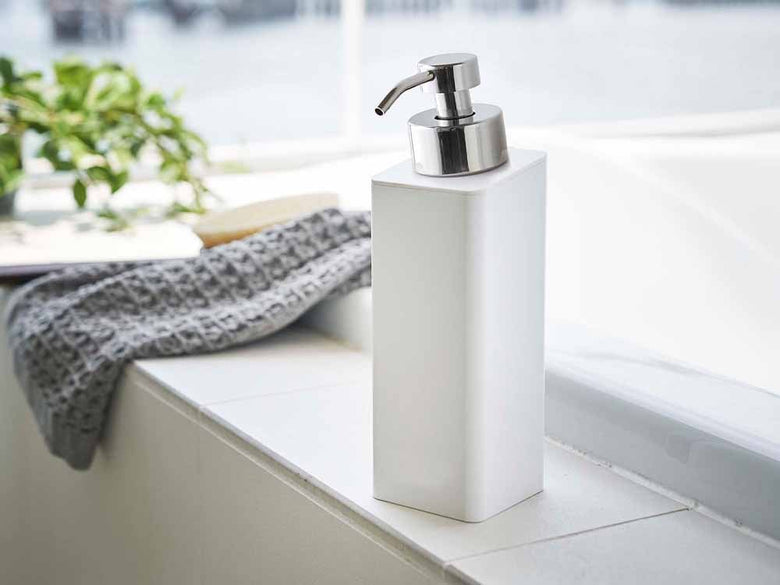 白いソープディスペンサーがシンクと蛇口に配置された浴室