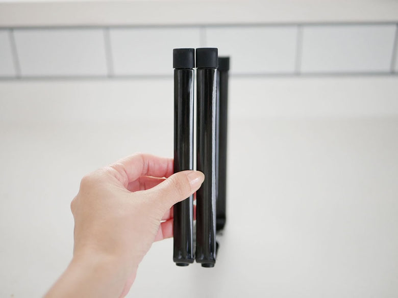 YAMAZAKIのタワー型ポリ袋エコホルダー。スチールとプラスチックでできた円筒形のデザインにパイプとカーボンファイバーの特徴を持つ製品。