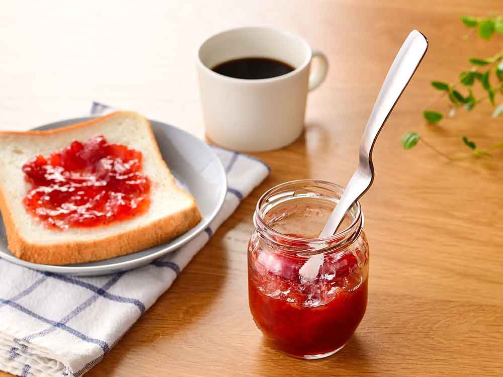 食卓にジャムヘラスプーンとパンが並べられた様子