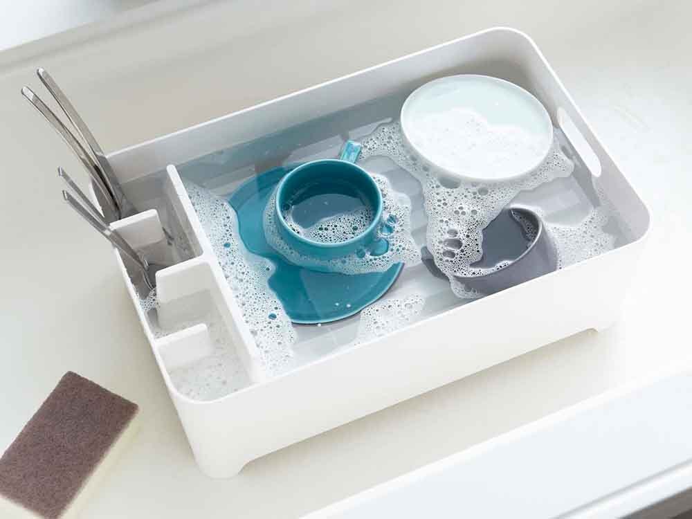 YAMAZAKI/towerのABS樹脂製水切りバスケットがキッチンシンク上に置かれている様子