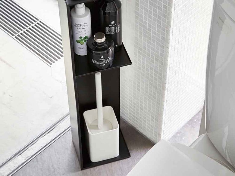 バスルームに設置されたYAMAZAKI/towerのスリムトイレラック。棚にはトイレットペーパーやペーパータオル、花鉢などが整理されています。