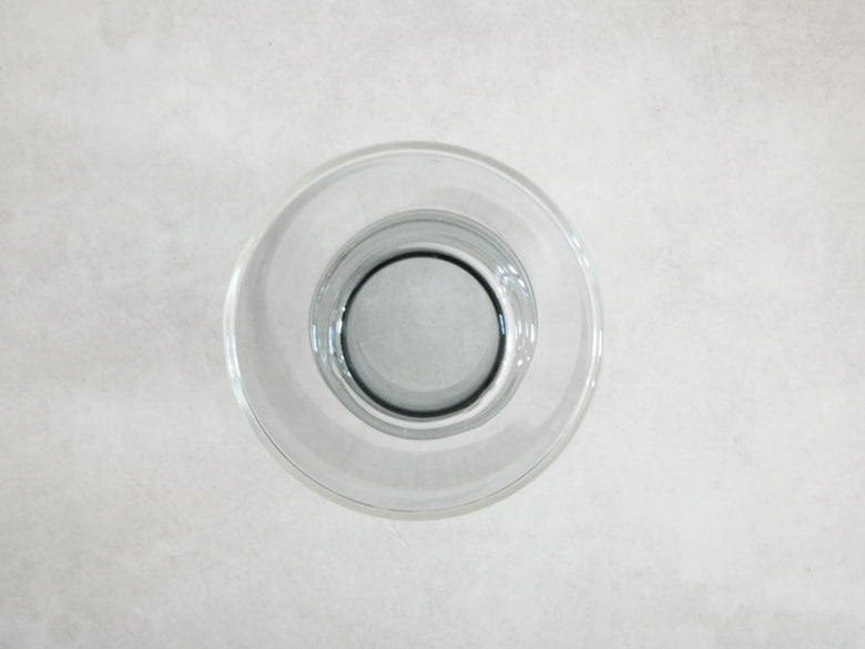 POSH LIVINGのガラス製フロートベース。透明なガラスボトルとシルバーの食器が並ぶ静物写真