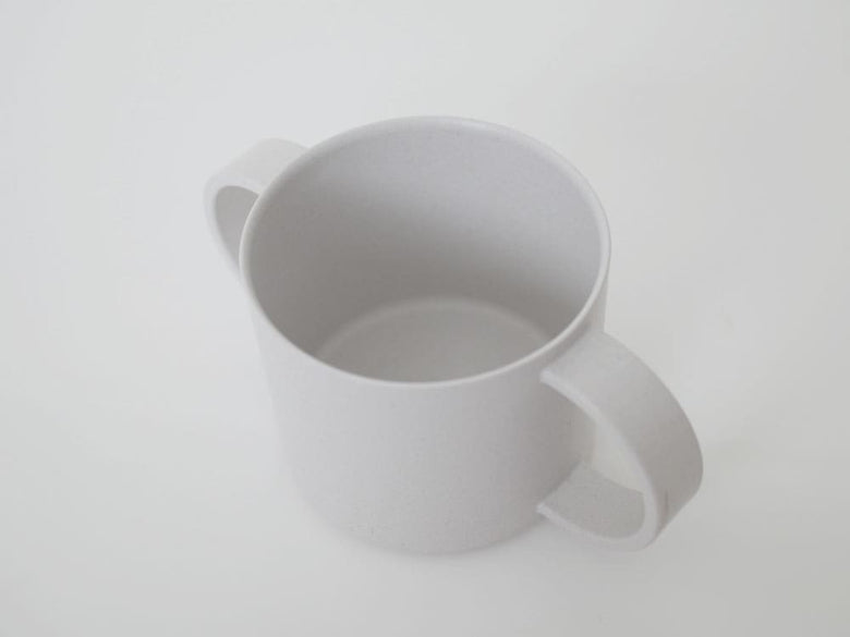 白いプラスチック製マグカップがテーブルに置かれています