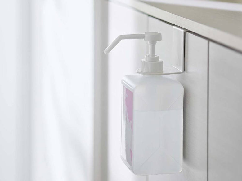 黒色のアルコール除菌ボトルホルダーがシンクに取り付けられています。