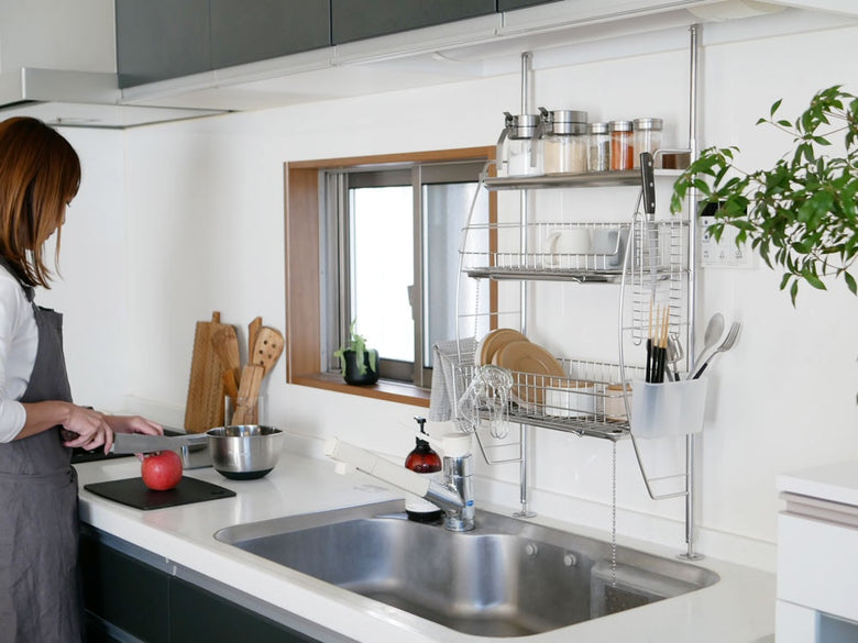 キッチンシンク上に設置された【bws SELECTION】流れるつっぱり水切りラック。ステンレス製の棚と水切りバスケットが見えます。