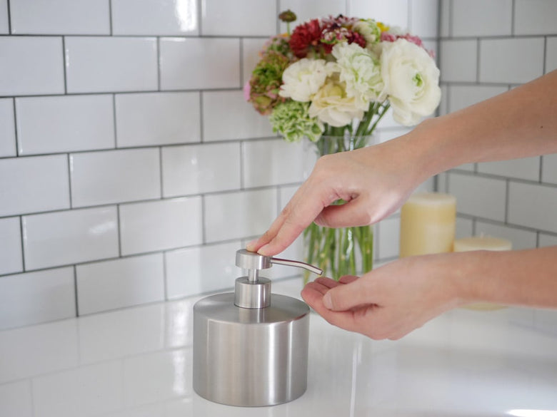 ステンレス製ダルトンソープディスペンサーがシンクに設置されている